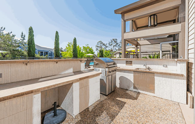 a large outdoor kitchen with a grill and a sink