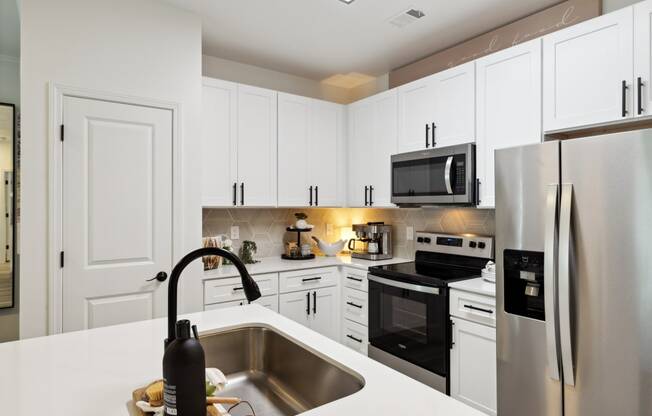 a kitchen with white cabinets and stainless steel appliances