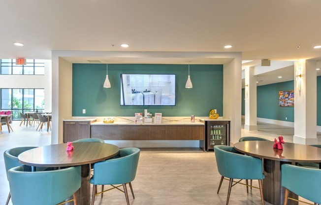 a dining room with tables and chairs and a tv on the wall at Pinnacle Apartments, Florida, 32256