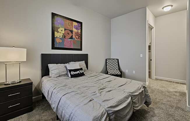 a bedroom with a queen sized bed and a painting on the wall