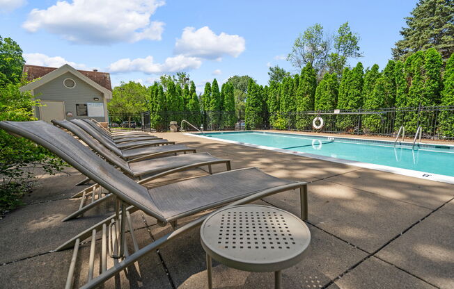 a group of chaise lounge chairs next to a pool