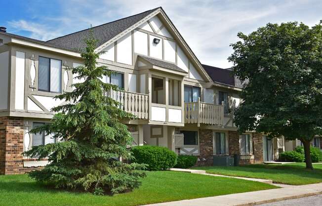 an apartment building with two large trees in front of it at Beacon Hill and Great Oaks Apartments, Rockford, IL, 61109