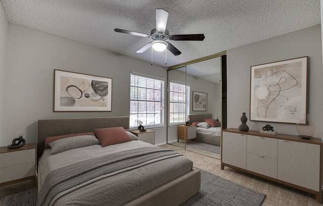 A bedroom with a large bed and a ceiling fan.