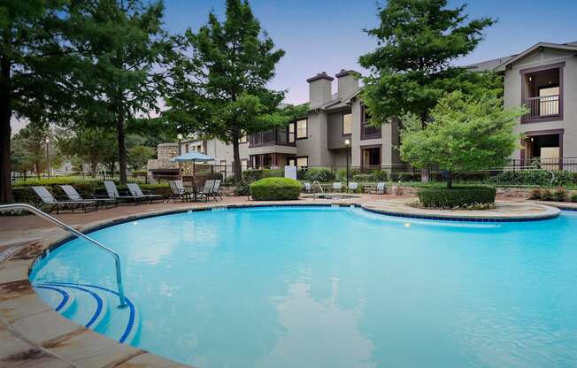 a swimming pool with an apartment building in the background