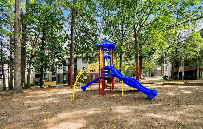 A playground with a blue slide and yellow structure.