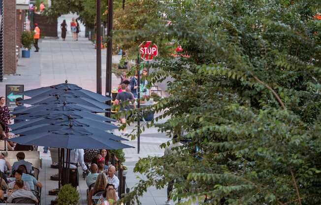 A group of people walking down a sidewalk in a city.