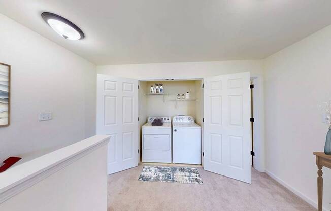 A white laundry room with a washer and dryer.