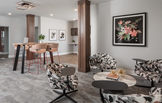 A living room with a grey carpet and a large painting on the wall.