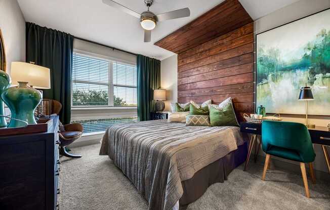 A bedroom with a bed, desk, and chair.