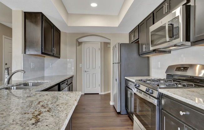 a kitchen with stainless steel appliances and marble counter tops