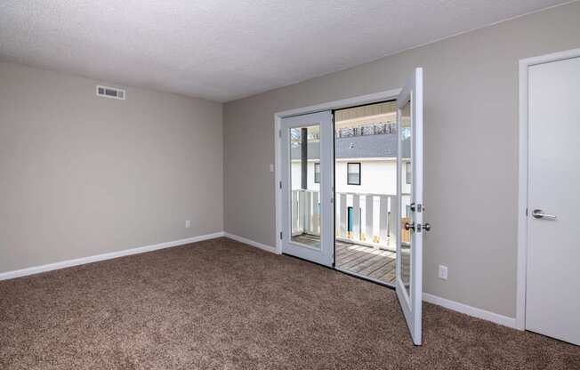 an empty living room with a door to a balcony at Cleo Apartments, Athens, AL