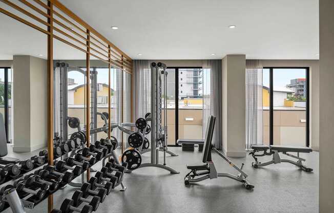 A gym with a row of dumbbells and weight machines. at Palma, Doral, FL, 33166
