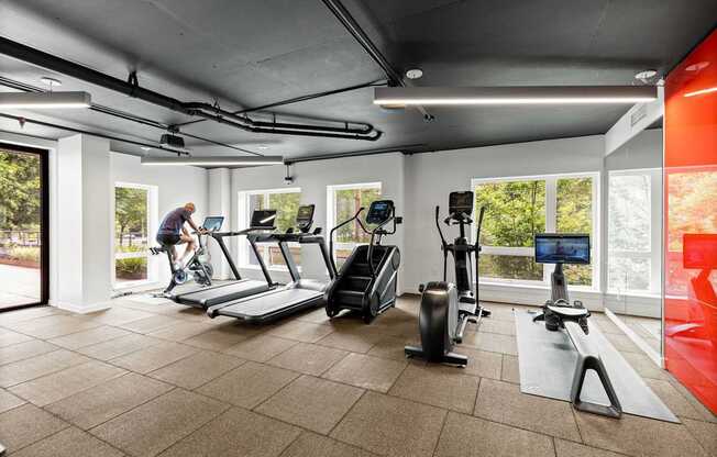 A man is working out on a stationary bike in a gym.