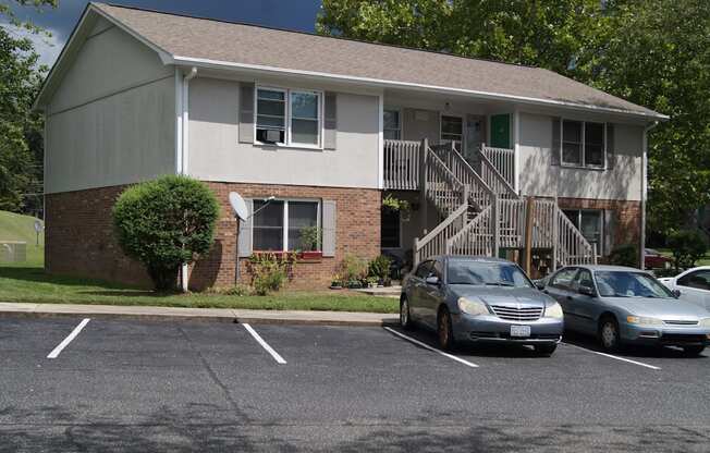 an apartment building with cars parked in a parking lot