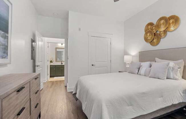 A bedroom with a bed, dresser, and ceiling fan.