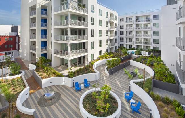 Apartments in Woodland Hills, CA - The Q Variel - Outdoor Courtyard with Chairs, Tables, Beautiful Landscaping, and Views of Patios/Balconies