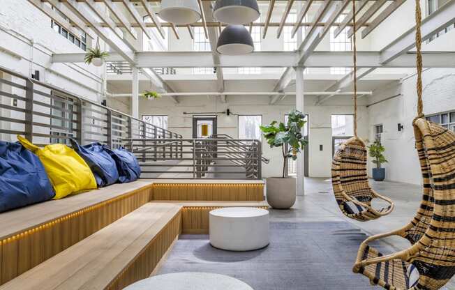 a living room with two hammock chairs and a wooden bench at Highland Mill Lofts, Charlotte, 28205