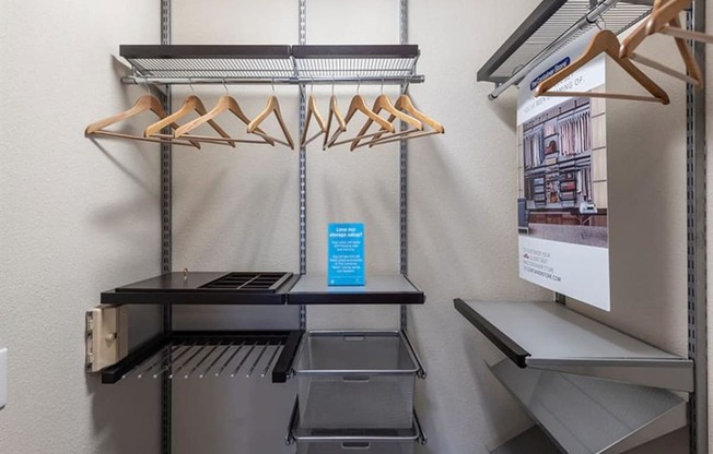 a walk in closet with a refrigerator and racks
