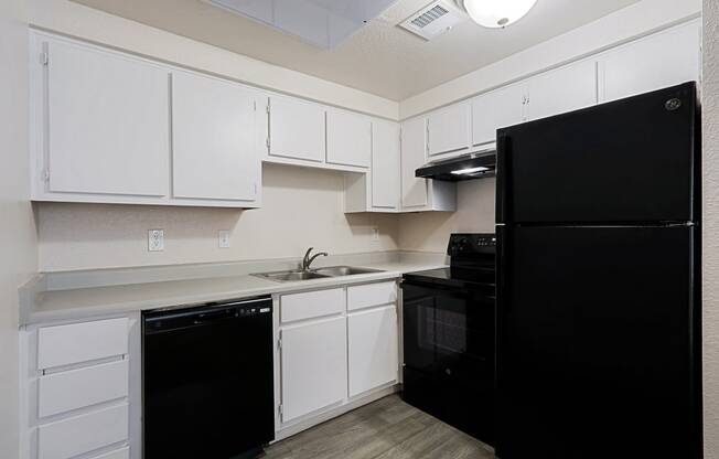 a kitchen with black appliances and white cabinets
