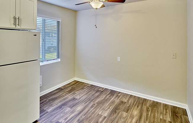 Dining area with ceiling fan, wood style flooring and window.at Woodhaven, Everett, 98203