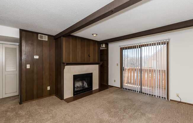 West One Bedroom Living Room, Fireplace, and Balcony Door at Raintree Apartments, Topeka, KS, 66614