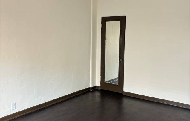 an empty living room with wooden floors and a ceiling fan