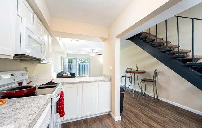 a kitchen with a sink and a stove and a staircase