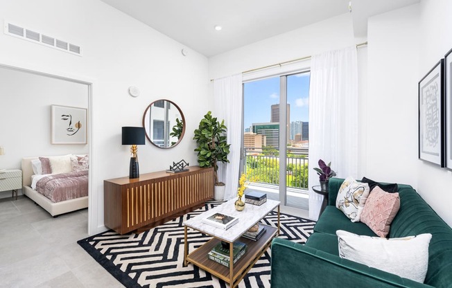 a living room with a green couch and a large window with a view of the city