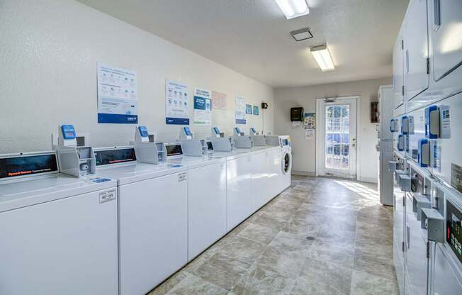 A laundromat with washers and dryers lined up.