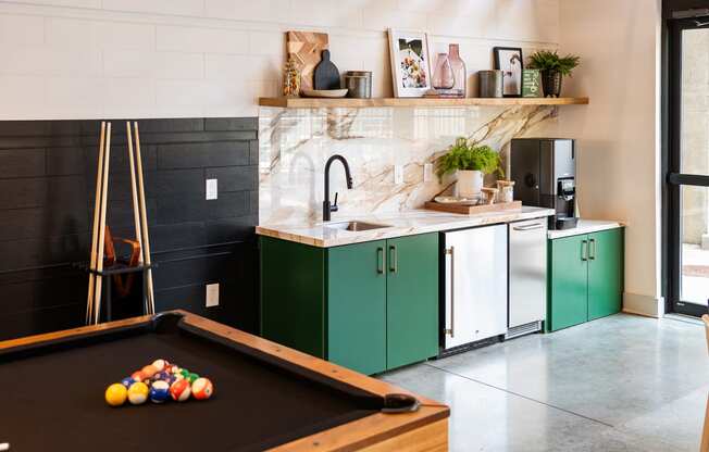 a kitchen with green cabinets and a pool table