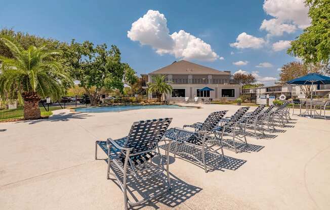 A row of metal chairs are lined up on a concrete surface.