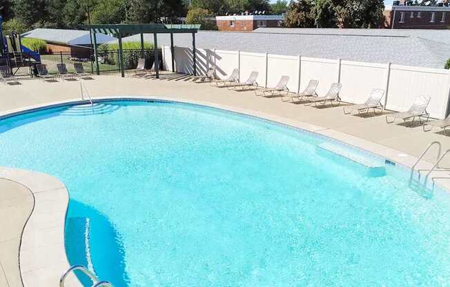 A large swimming pool with a white fence around it.