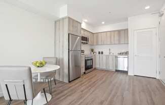a kitchen and dining area with a table and chairs and a refrigerator