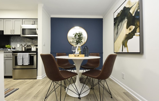 a dining room with a table and chairs and a blue accent wall