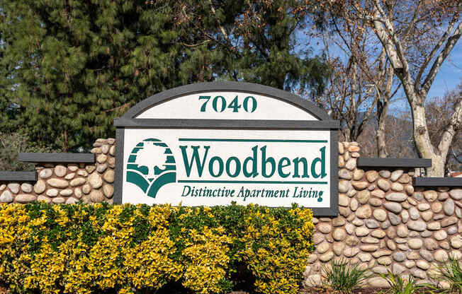 A sign for Woodbend Distinctive Apartment Living with a number 7040 on it.