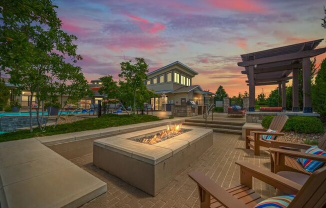 a patio with chairs and a fire pit