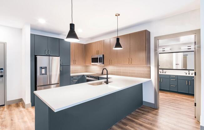 A clean, contemporary kitchen with bold cabinetry, generous counter space, and designer lighting.