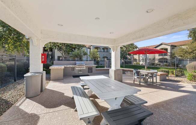 A white covered patio with tables and benches.