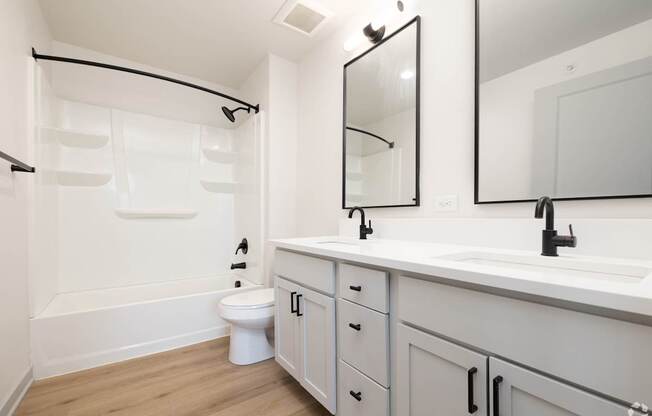 A white bathroom with a toilet, sink, and mirror.