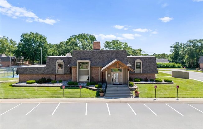 A small building with a parking lot in front.