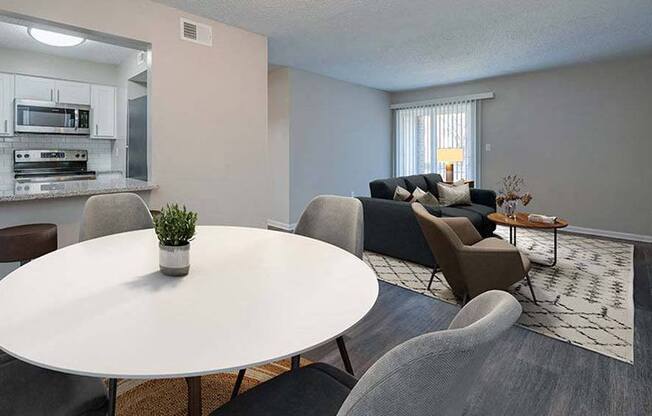 a living room and kitchen with a table and chairs