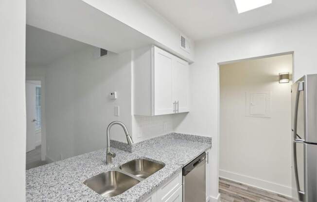 A kitchen with a granite countertop and stainless steel appliances.