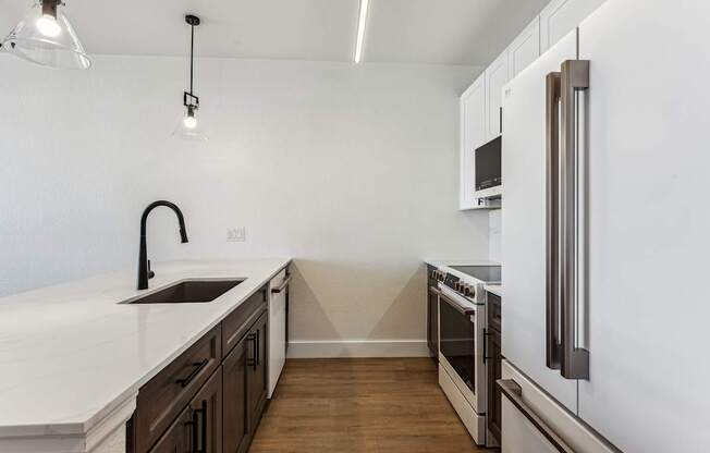 A modern kitchen with a white countertop and dark brown cabinets.