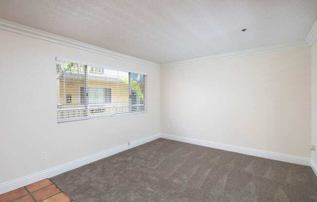 Front room with custom blinds over large window at the Atrium Apartments in San Diego, California.