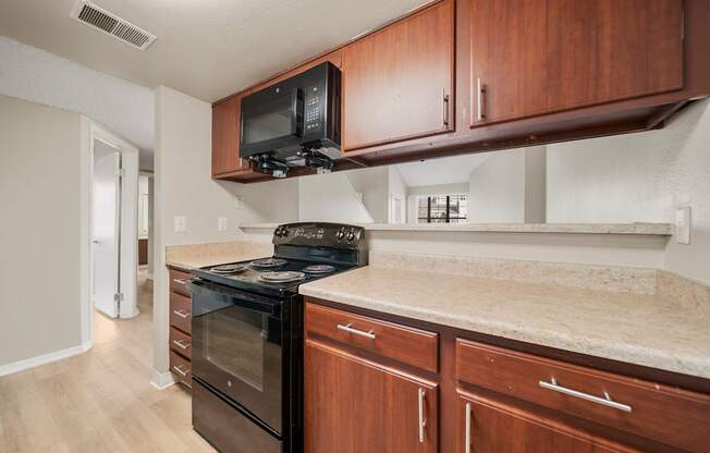 A kitchen with a black oven and microwave above it.
