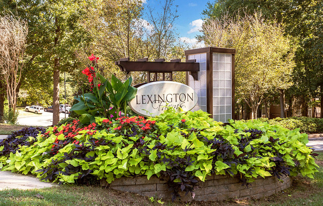 a sign in front of a garden of flowers