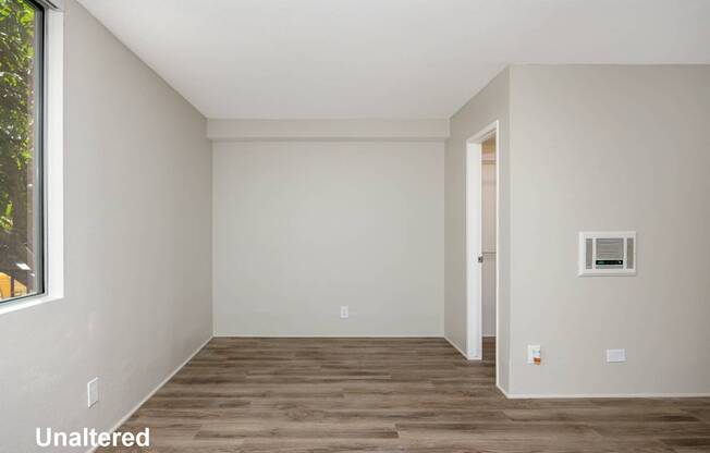 A room with wooden flooring and white walls.