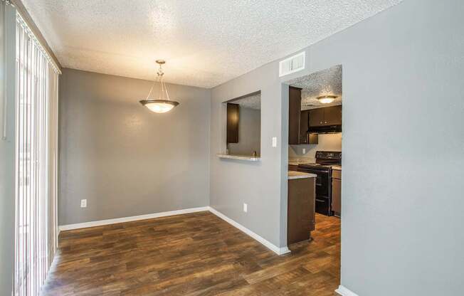A room with wooden floors and a light hanging from the ceiling.
