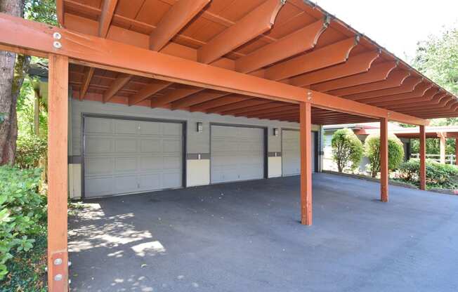 a carport with two garage doors on the side of a house