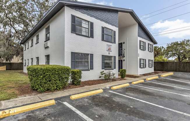 a white apartment building with a parking lot